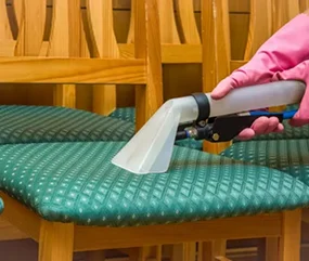 A gloved hand holds a upholstery cleaner