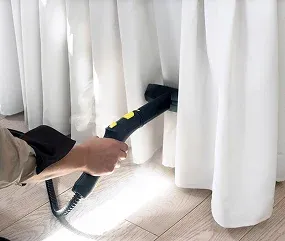 A person using a handheld steam cleaner