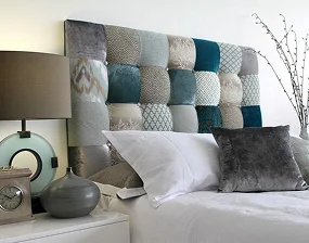 A stylish bed with a colorful patchwork headboard