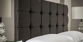 Elegant tufted dark gray headboard above a white bed