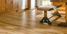 Light wooden floor with a rustic table and a folded blanket